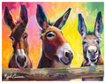 Tres Donkeys by Miguel Camarena, a colorful painting of three donkeys peeking over a wooden fence against a bright pink, yellow, and green background.